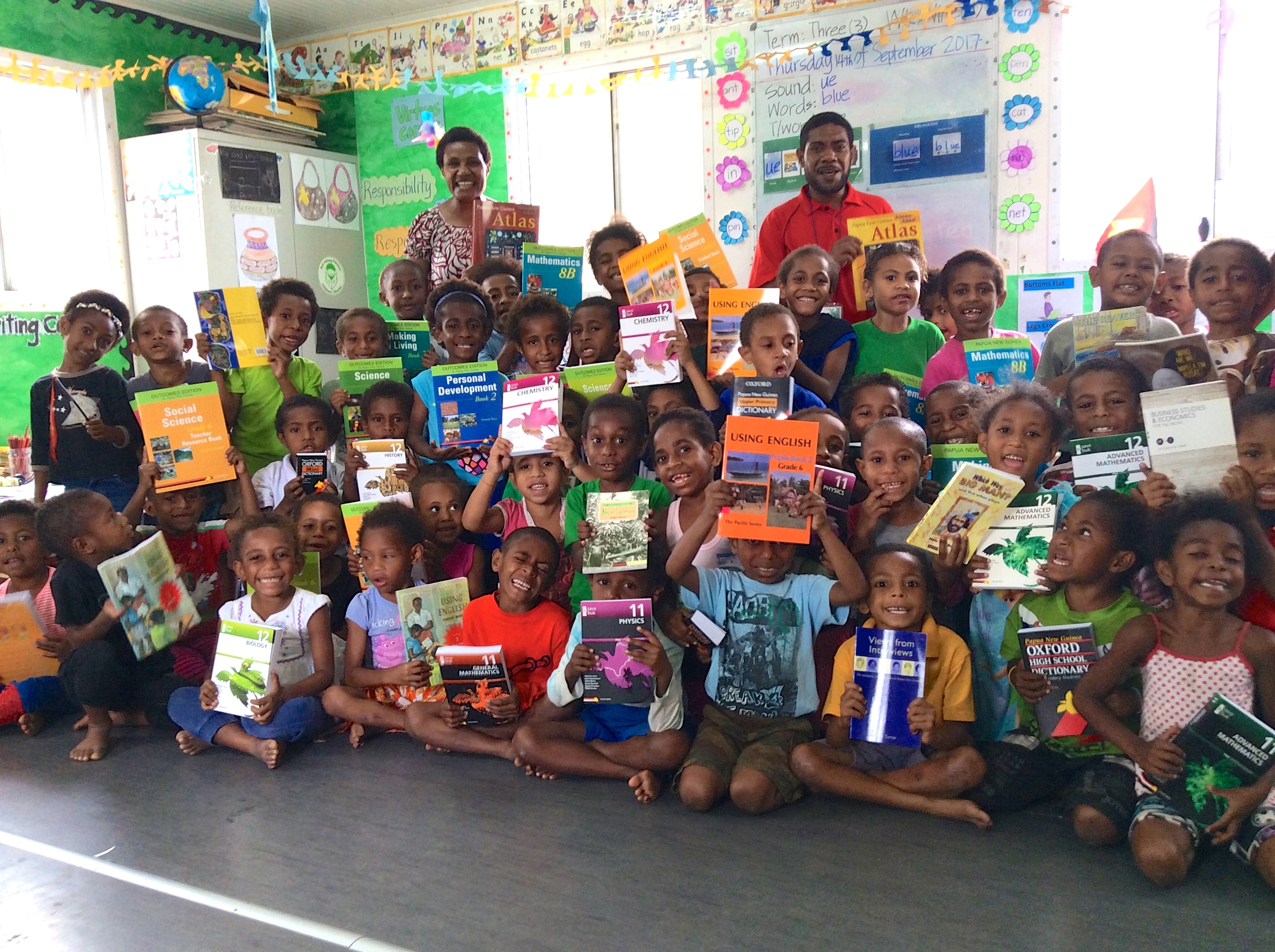 Smiling faces greet a donation of OUP books to Buk bilong Pikinini