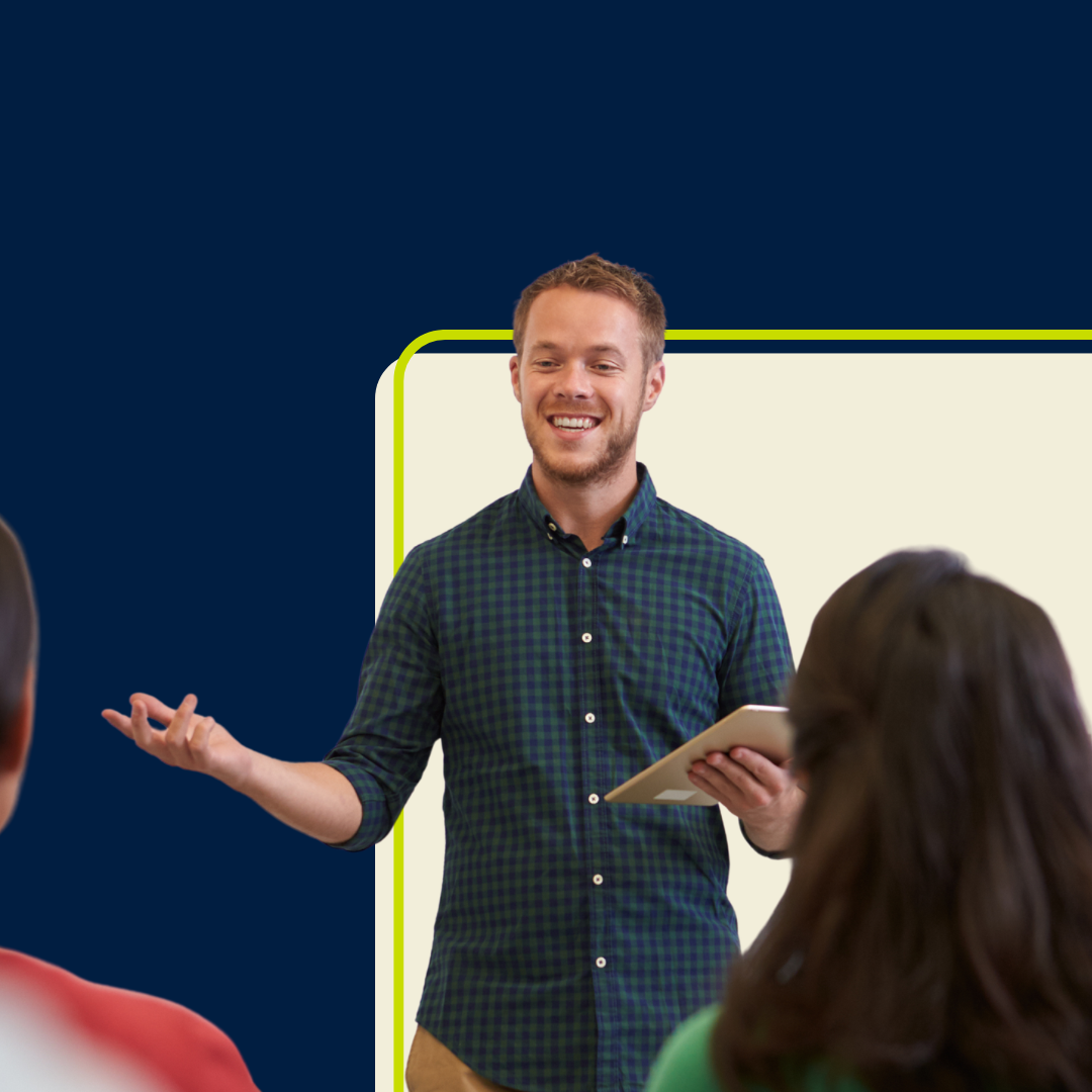 A male teacher standing at the front of the class of students